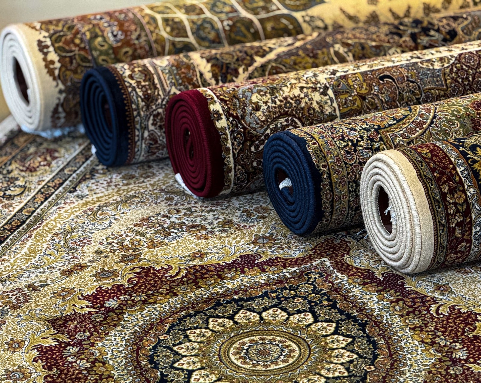 Rolls of patterned rugs on a surface